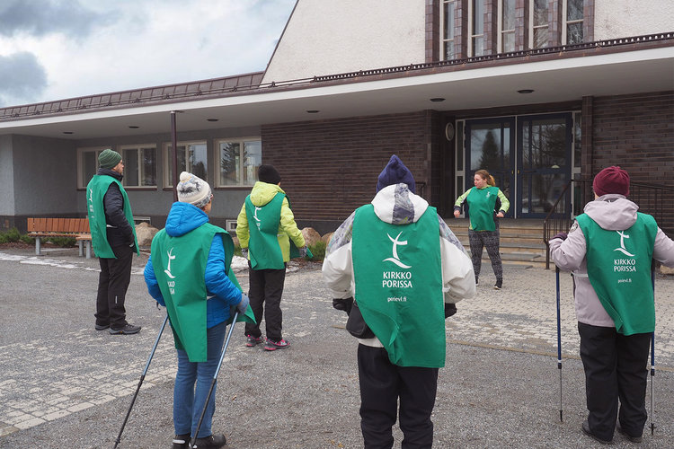 Diakonissa harjoittelija Charlotta Vuori ohjaa alkulämmittelyä Länsi-Porin kirkon edustalla. 