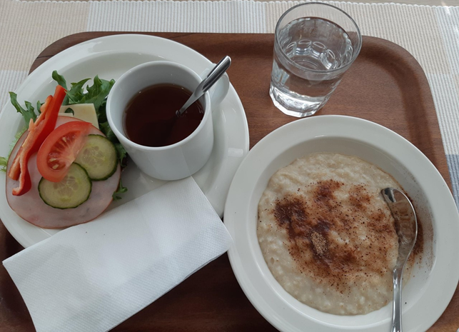Diakonian aamupalahetki Väinölässä Tarjottimella valmis aamupala, jossa puurolautanen, teemuki ja voileipä sekä servetti.